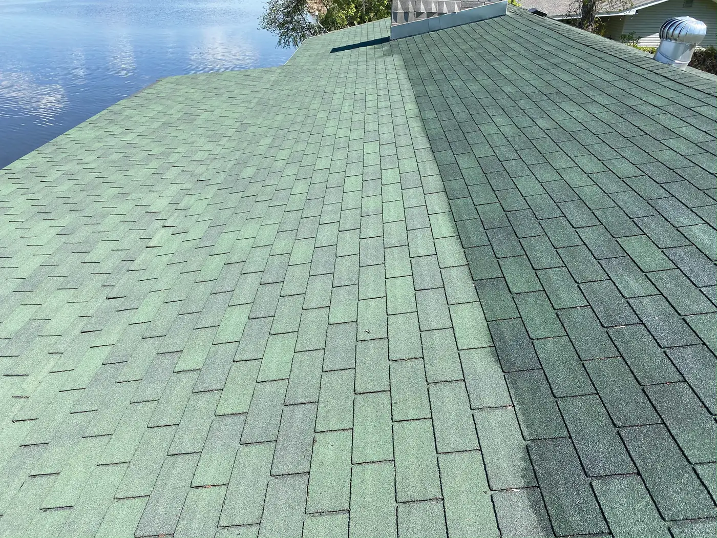 Asphalt shingle roof with the faded untreated half on the left and the darker, richer treated half on the right
