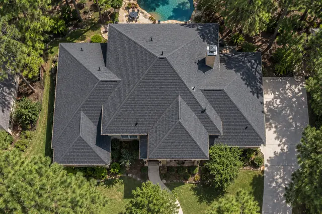 Top-down view of a hip roof with dark architectural shingles
